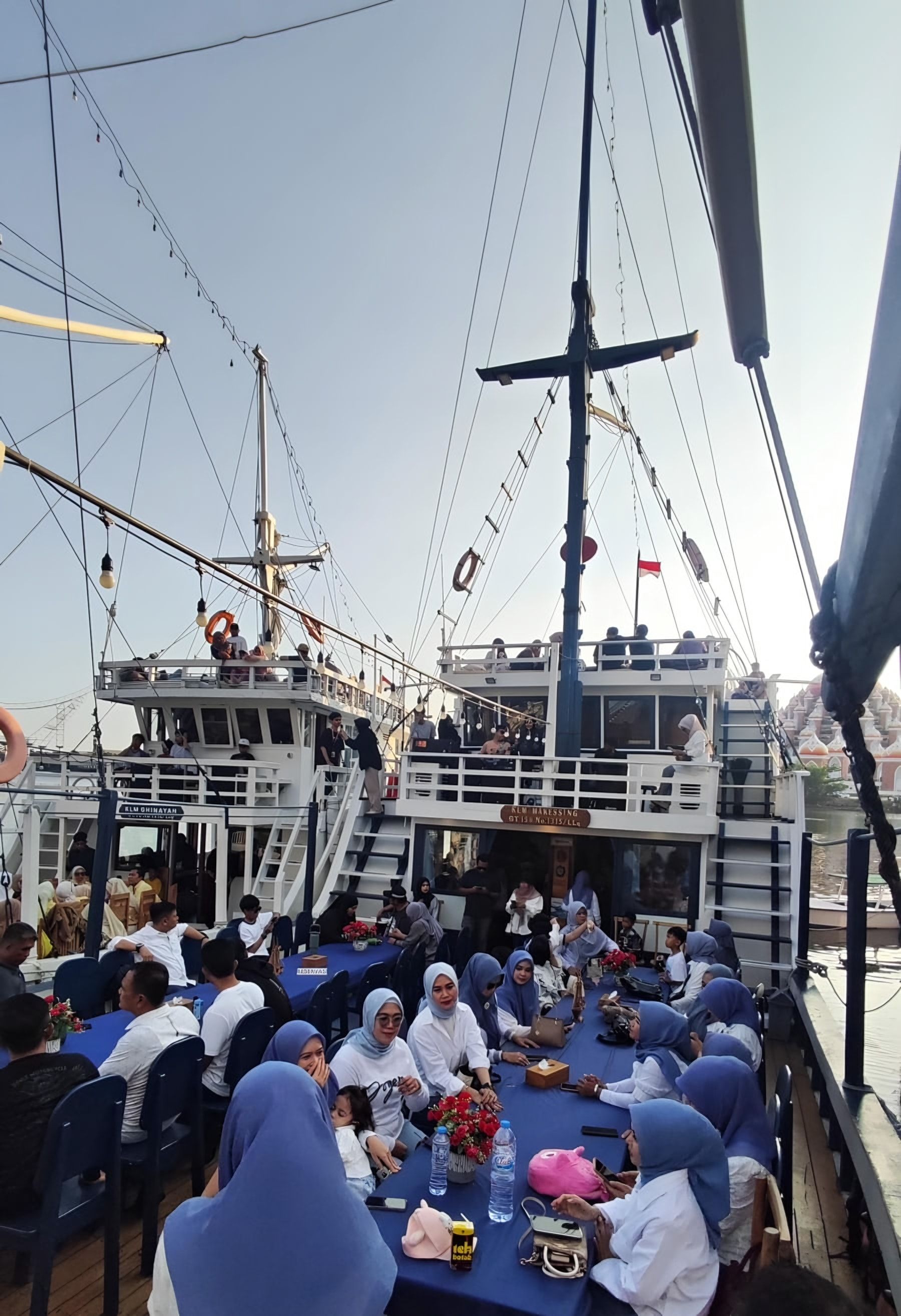 Rombongan arisan di dek kapal, Masjid 99 Kubah terlihat di kejauhan