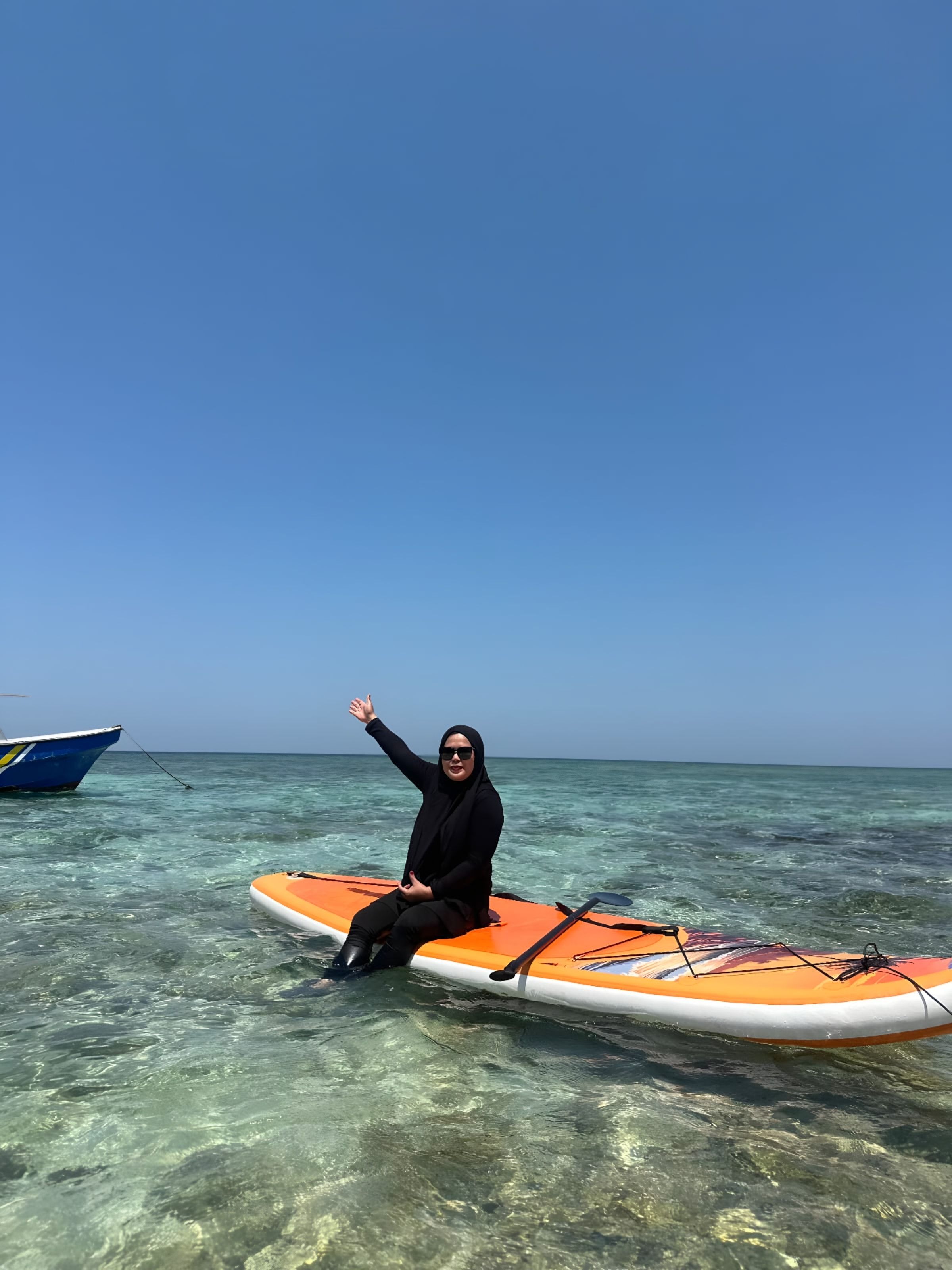 Tamu duduk di paddle board di perairan dangkal yang jernih dekat Pulau Samalona